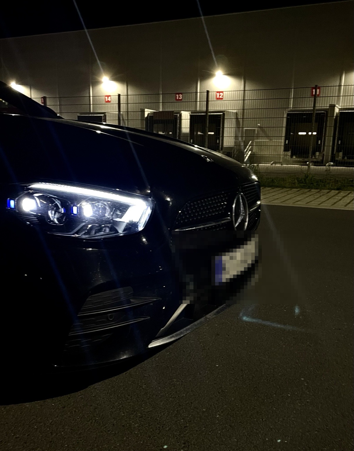 Mercedes E‑Klasse bei Nacht (Kennzeichen zensiert)